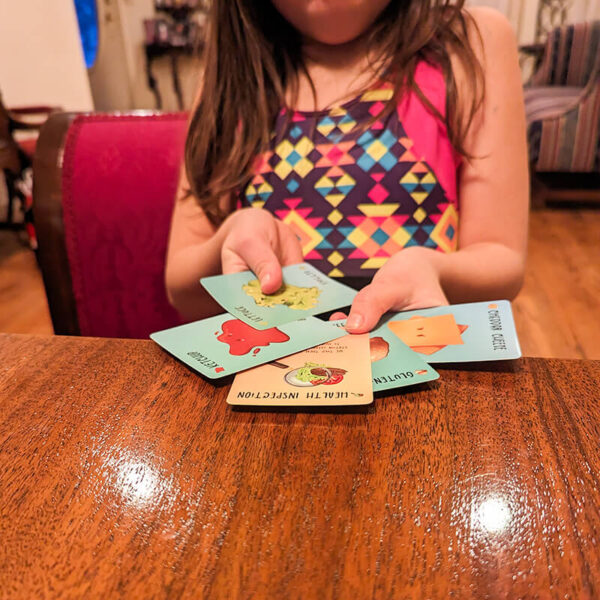 Child holding an open hand of cards